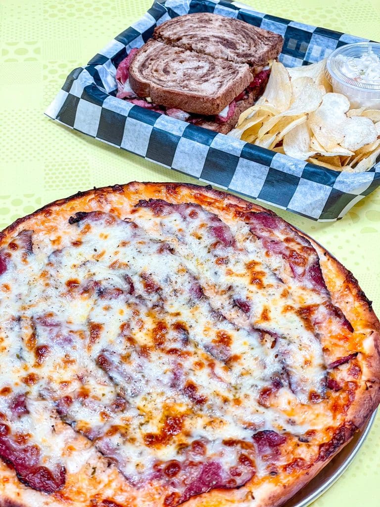 A pizza and a basket of chips
Description automatically generated