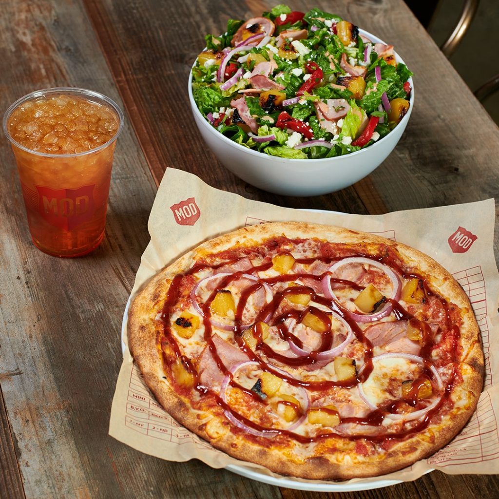 A pizza and salad on a table
Description automatically generated