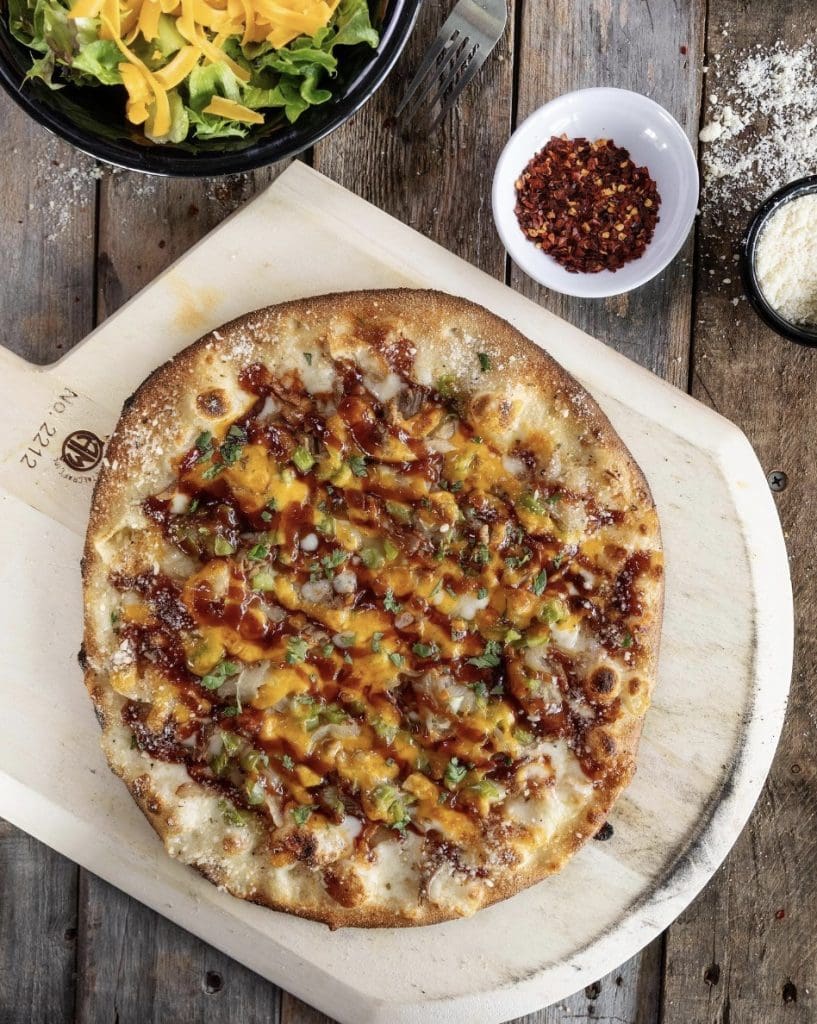 A pizza on a cutting board
Description automatically generated