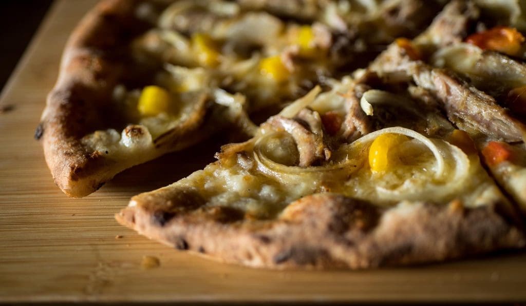 A pizza with corn and cheese
Description automatically generated