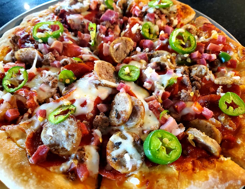 A pizza with jalapenos on it
Description automatically generated