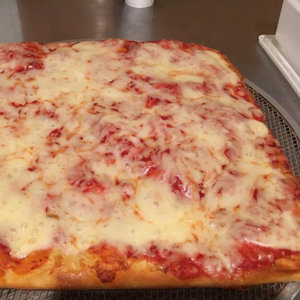 A square pizza on a metal tray
Description automatically generated